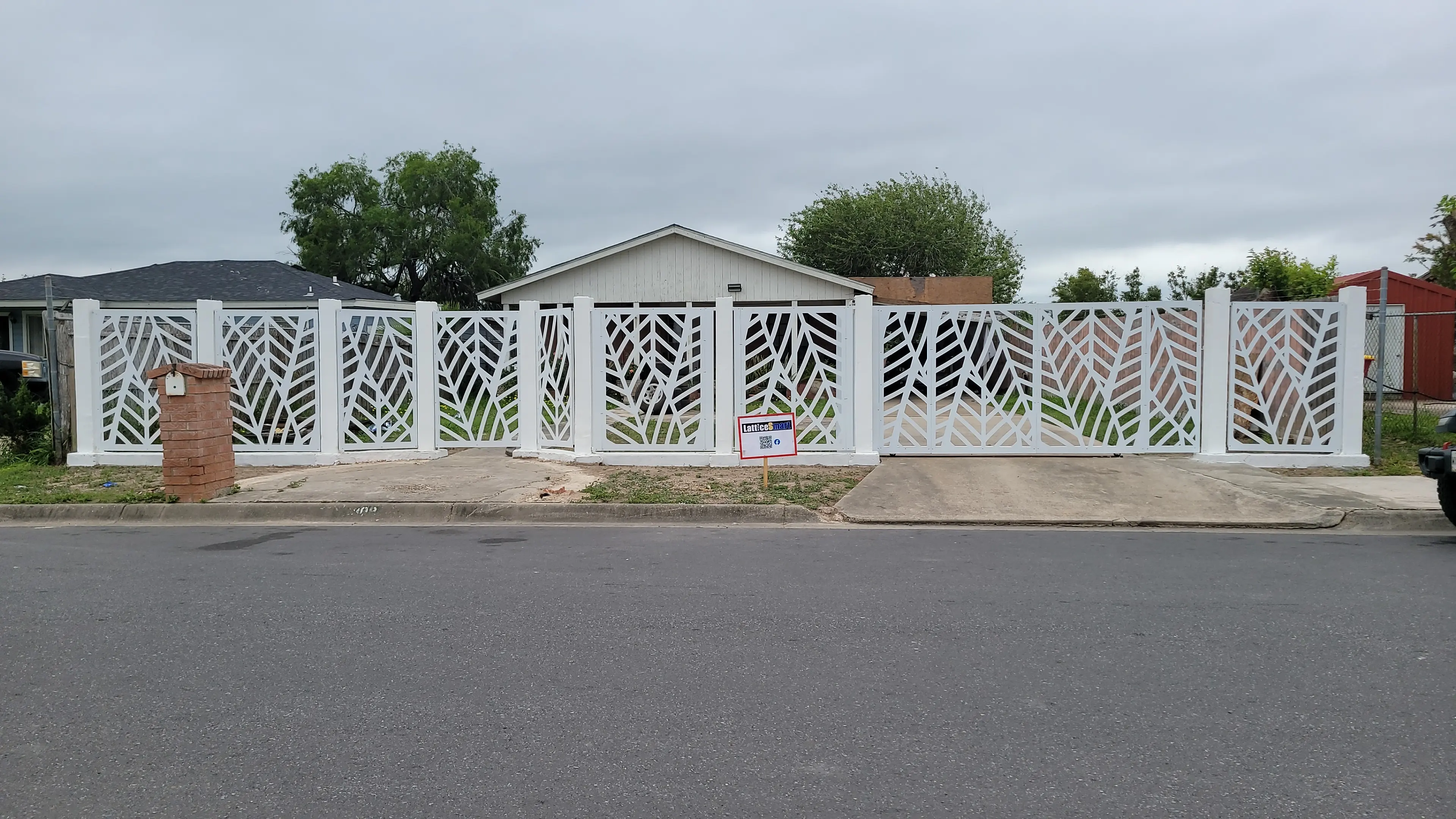White decorative fence across a home exterior